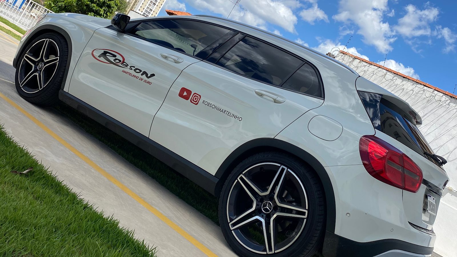 Carro branco com a marca Robson Martelinho de Ouro na lateral
