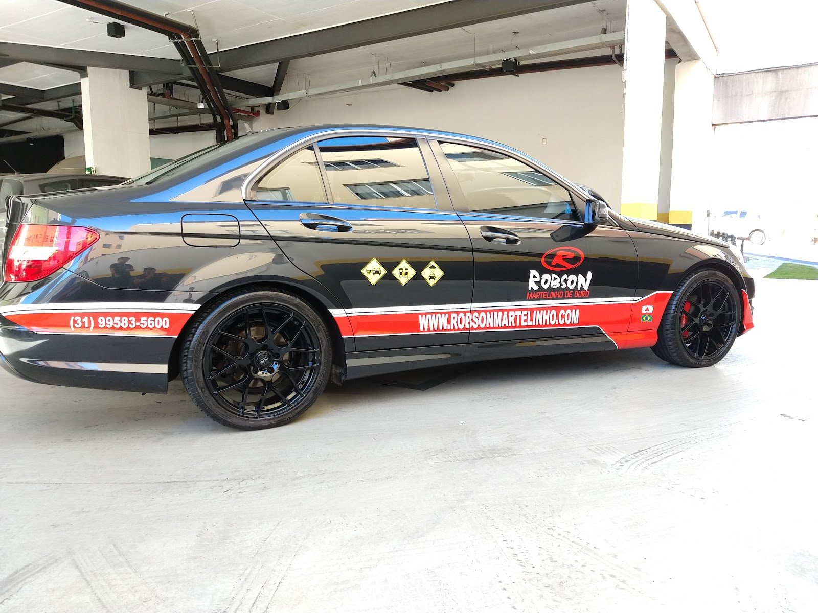 Carro preto da empresa, com o nome e o telefone da Robson Martelinho de Ouro na lateral